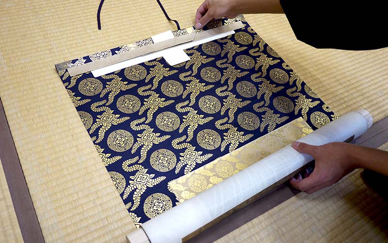 掛軸を途中まで広げる